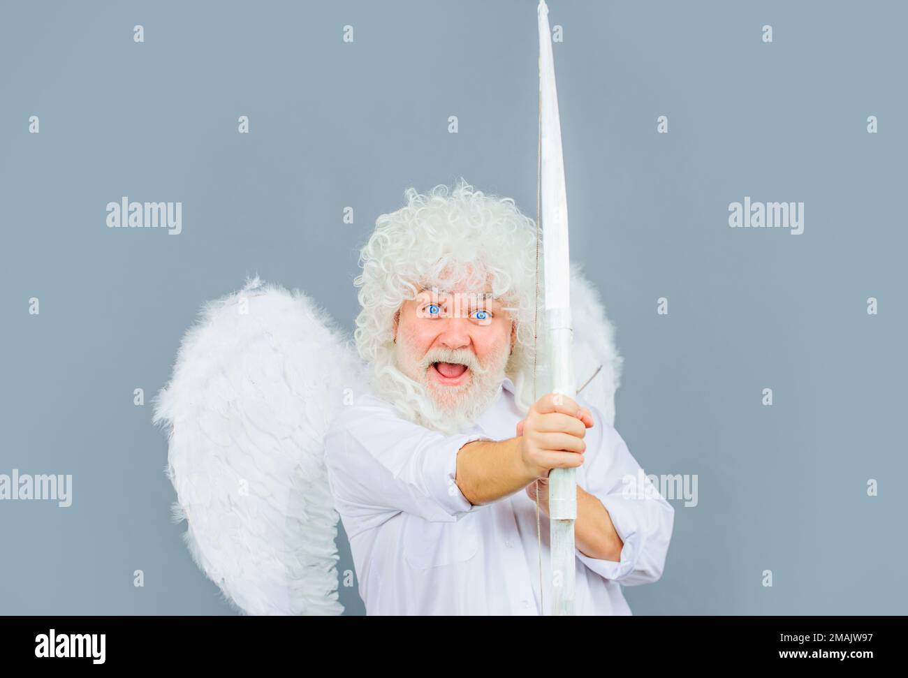Cupid throws love arrow with bow for valentines day. Male angel in angelic wings. God of love Stock Photo
