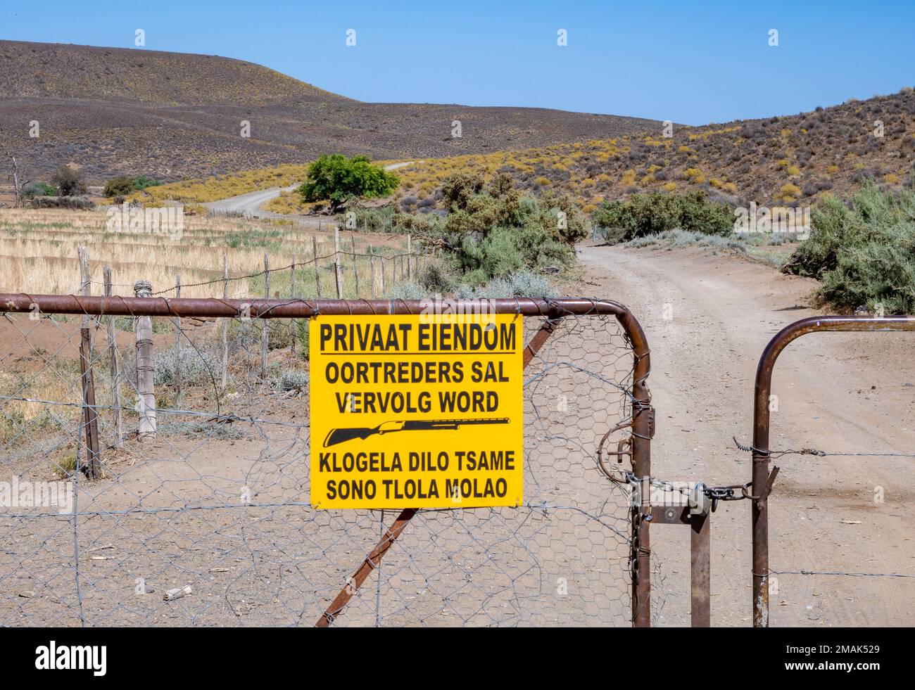 A warning sign on iron gate of a private property. Northern Cape, South Africa. Stock Photo
