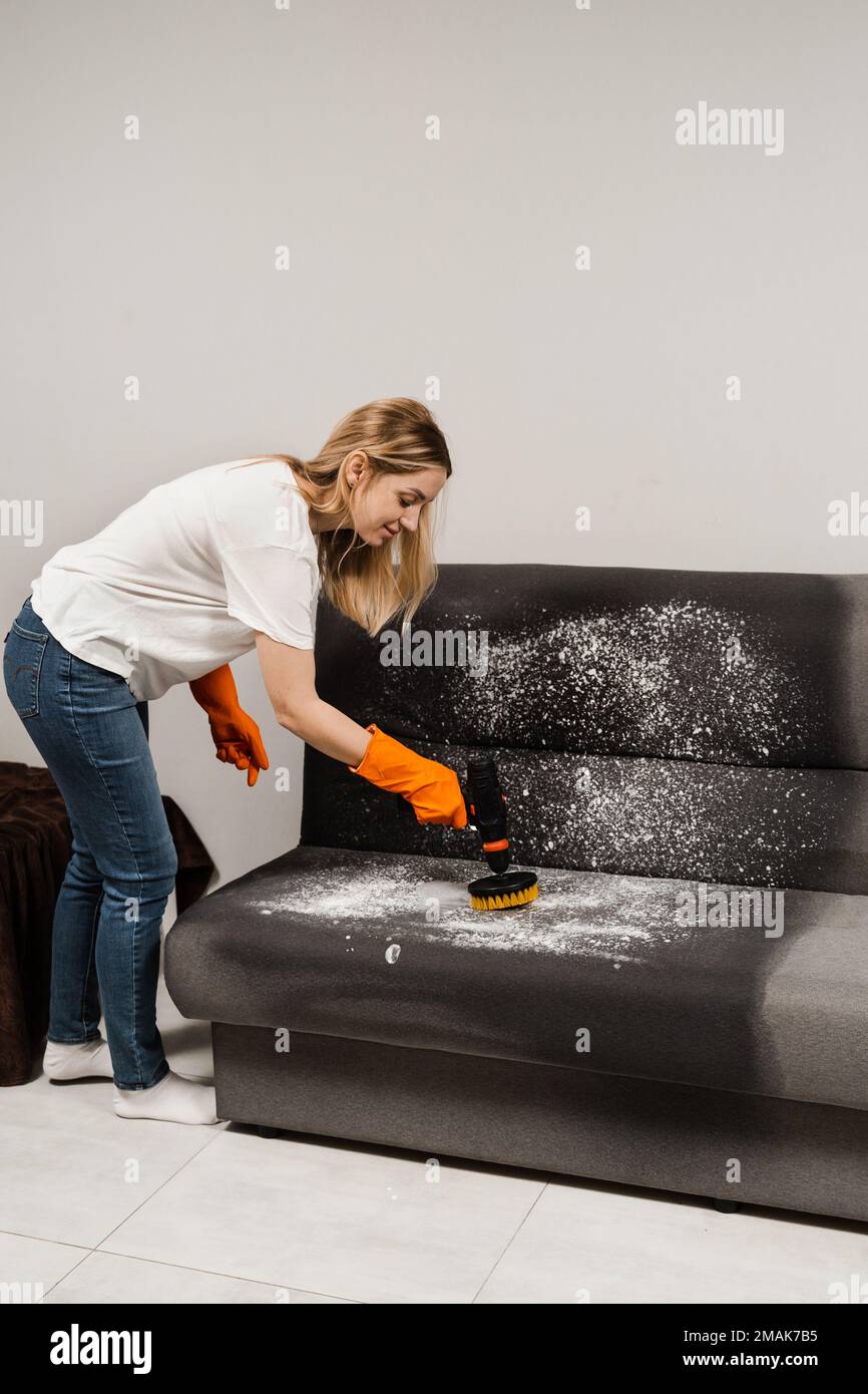 Applying detergent on couch for dry cleaning using extractor machine