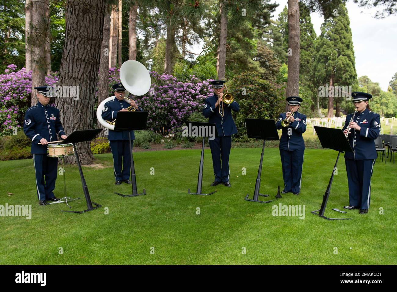 U.S. Air Forces in Europe Band provides musical support during a Memorial Day ceremony at the Brookwood American Military Cemetery, England, May 29, 2022. Memorial Day provides us a solemn opportunity to remember our fallen brothers and sisters in arms, reflect upon their courageous sacrifice, and show gratitude for the freedom they gave their lives to defend. It also affords us the opportunity to pay homage to those families who lost their loved ones in service to the Nation-and continue to feel the full weight of that sacrifice today. Stock Photo