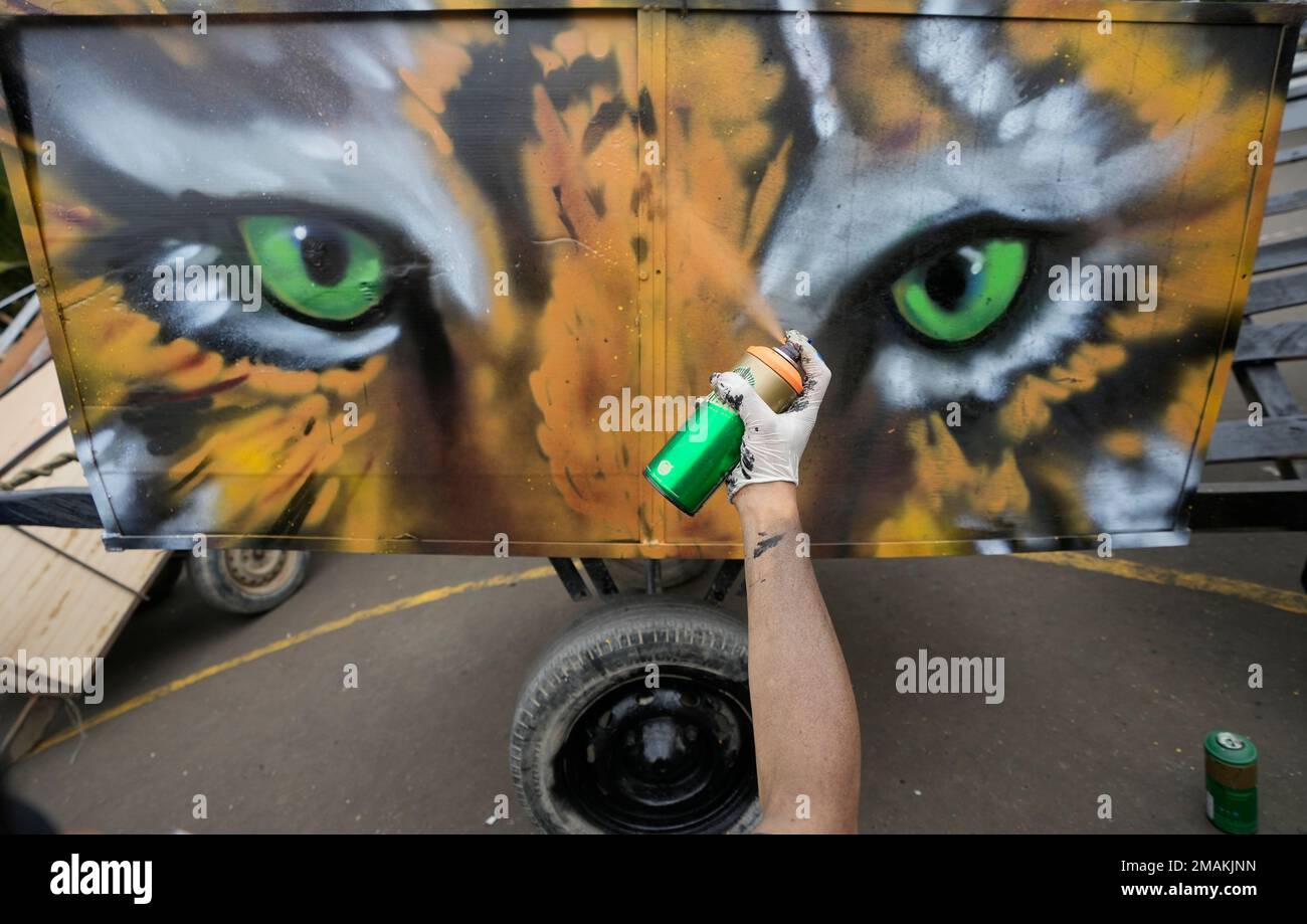 Collectinf Drawing An artist spray paints a mural on the carts of recyclable material ...