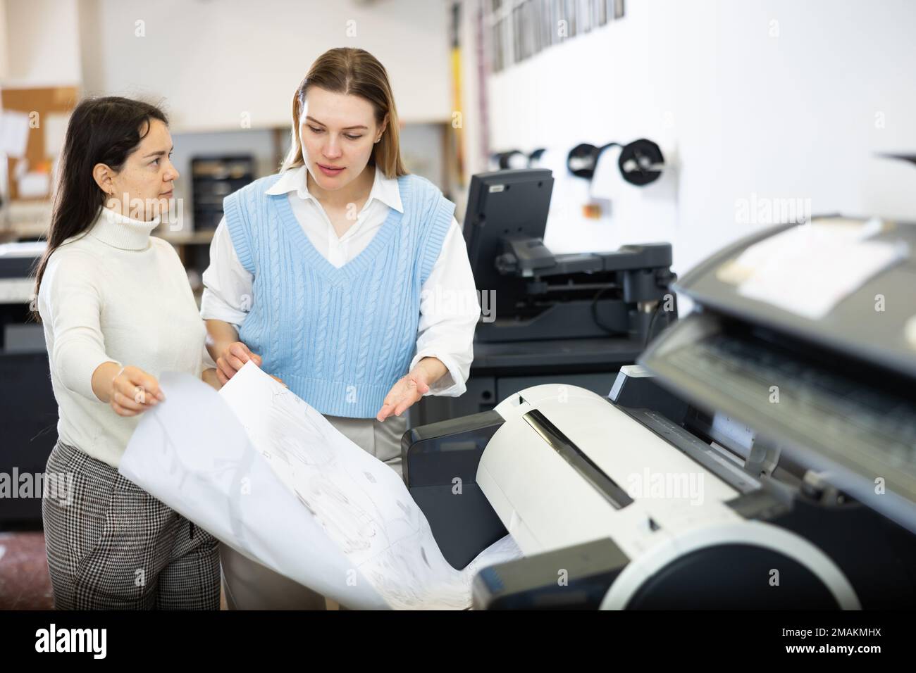 Female printing office workers talking about job Stock Photo Alamy