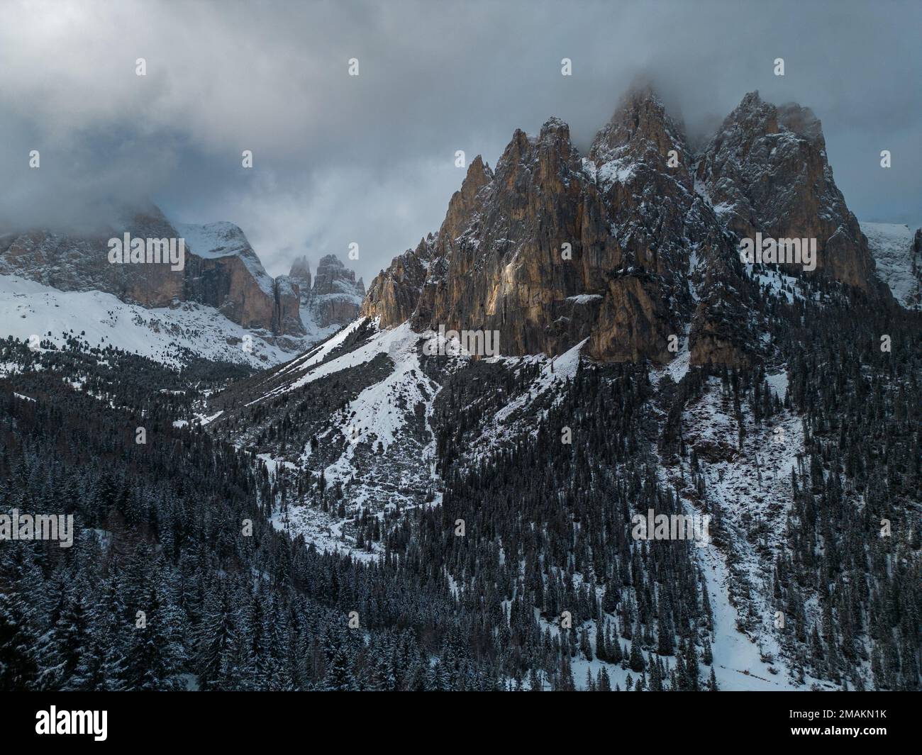 A drone aerial shot of Rosengarten Group massif (or Rose Garden massif) at Vigo di Fassa, in the Dolomites of northern Italy at sunset in winter. Stock Photo