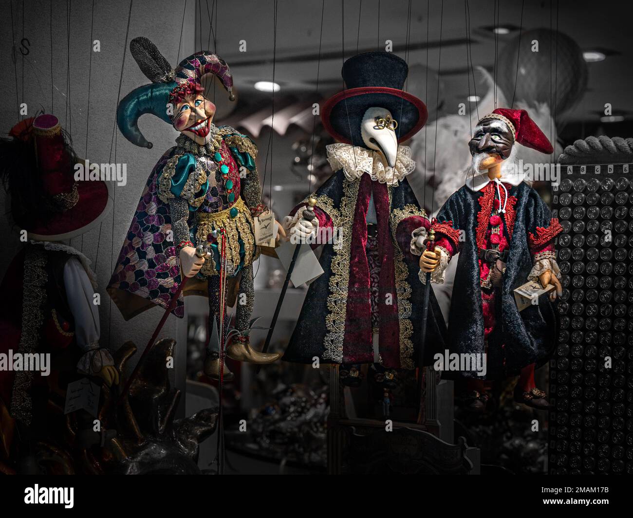 Three traditional dolls hang in a shop window Stock