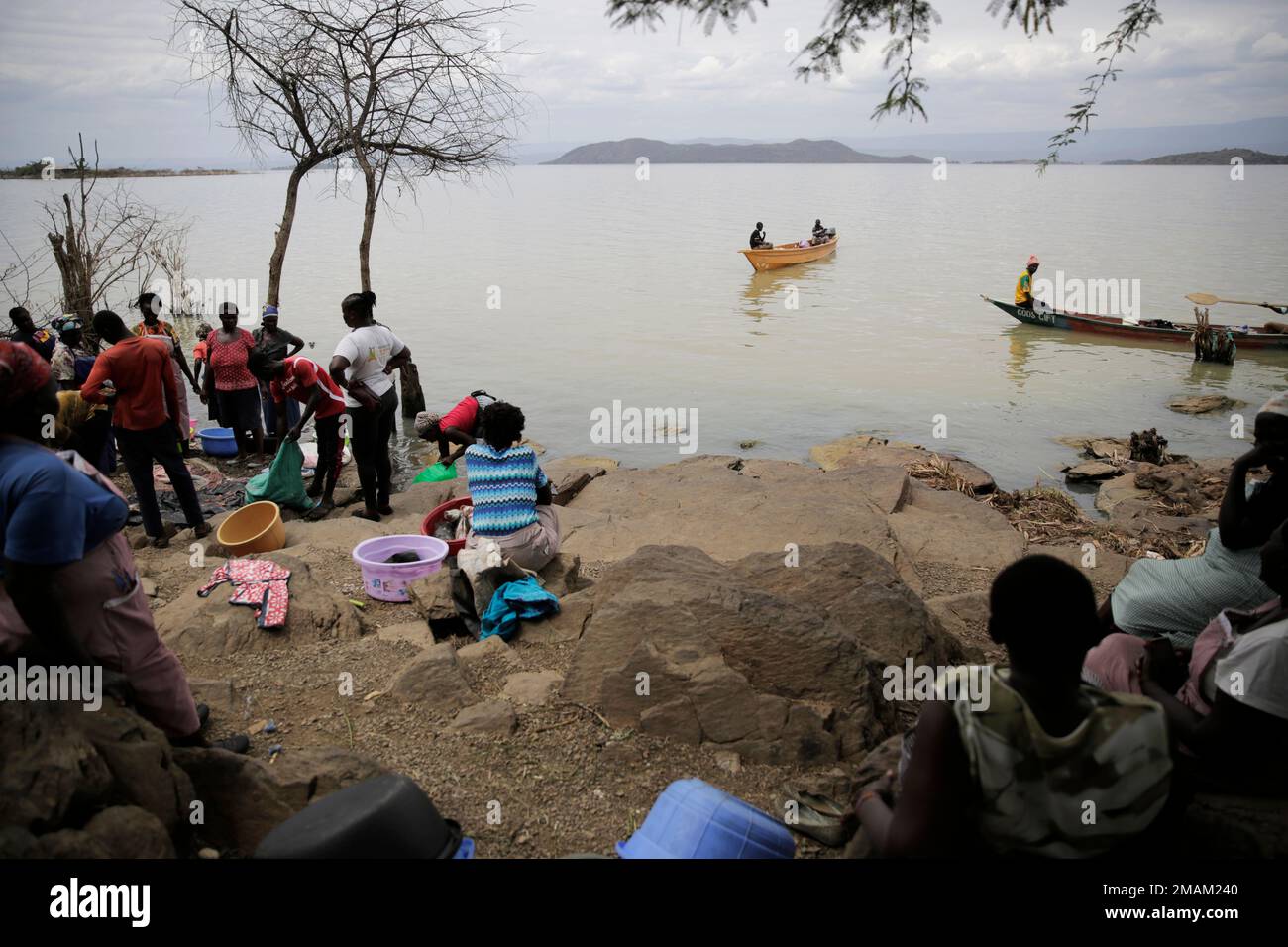 Women wait for fish after a catch by fishermen at Lake Baringo in Kampi ya  Samaki, Kenya, Thursday, July 21, 2022. Water is rising in part due to  climate change, and hippos