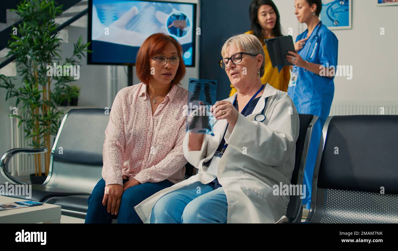 Scan Health Rx Old doctor and asian patient looking at x ray scan results, explaining ...