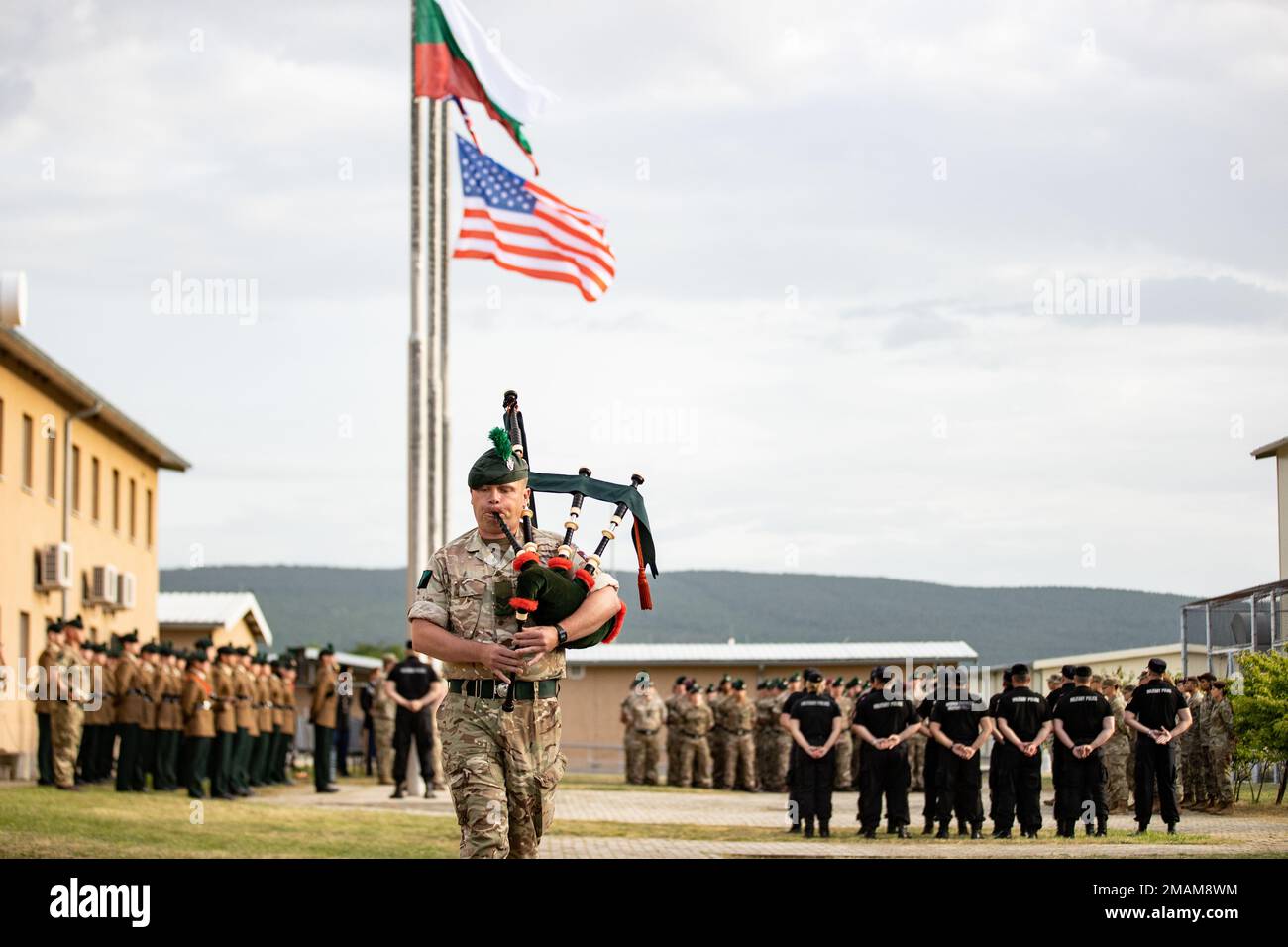 A British Army Soldier, assigned to Charlie Company, 1st Battalion, The Royal Irish Regiment, plays the bagpipe as Soldiers from the U.S. Army, British Army, and Bulgarian Land Forces stand in formation in honor of those who have made the ultimate sacrifice in service to their nation during a Memorial Day Ceremony at Novo Selo Training Area, Bulgaria, May 30, 2022. Stock Photo