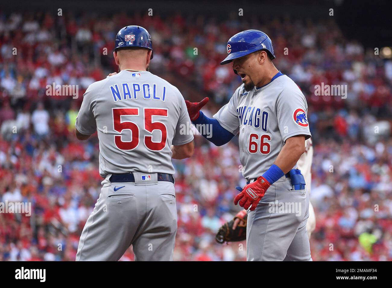 Chicago Cubs first base coach Mike Napoli (55) celebrates with Chicago Cubs'  Rafael Ortega (66) after Ortega hits a two-run single in the first inning  of a baseball game against the St.