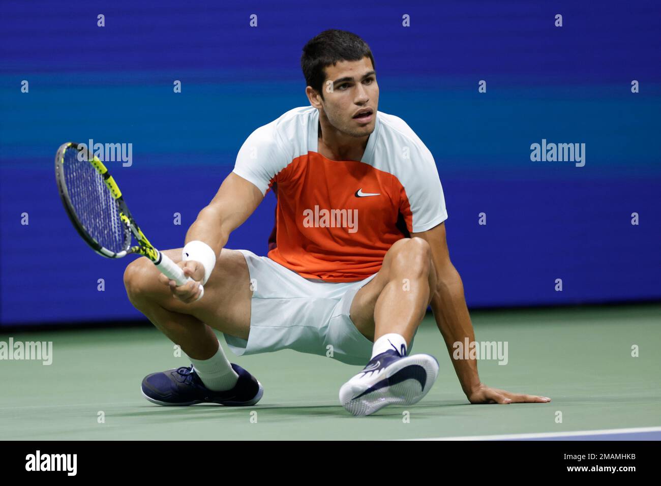 Carlos Alcaraz, of Spain, falls while returning a shot to Marin Cilic, of Croatia, during the fourth round of the U.S. Open tennis championships, Monday, Sept