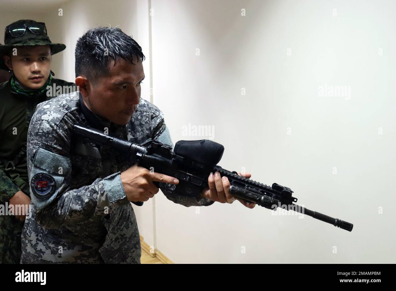 A member of the Philippine Coast Guard Special Operations Force and his Philippine National Police - Maritime Group, 2nd Special Operations Unit partner clear a room during a close-quarter battle drill demonstration observed by Green Berets from 1st Special Forces Group (Airborne), May 30, 2022, near Puerto Princesa, Palawan. This military engagement provided an opportunity for the Philippine National Police, Philippine Coast Guard Special Operations Force and U.S. Green Berets to exchange tactics, techniques and procedures with each other in an effort to enhance interoperability while sharing Stock Photo