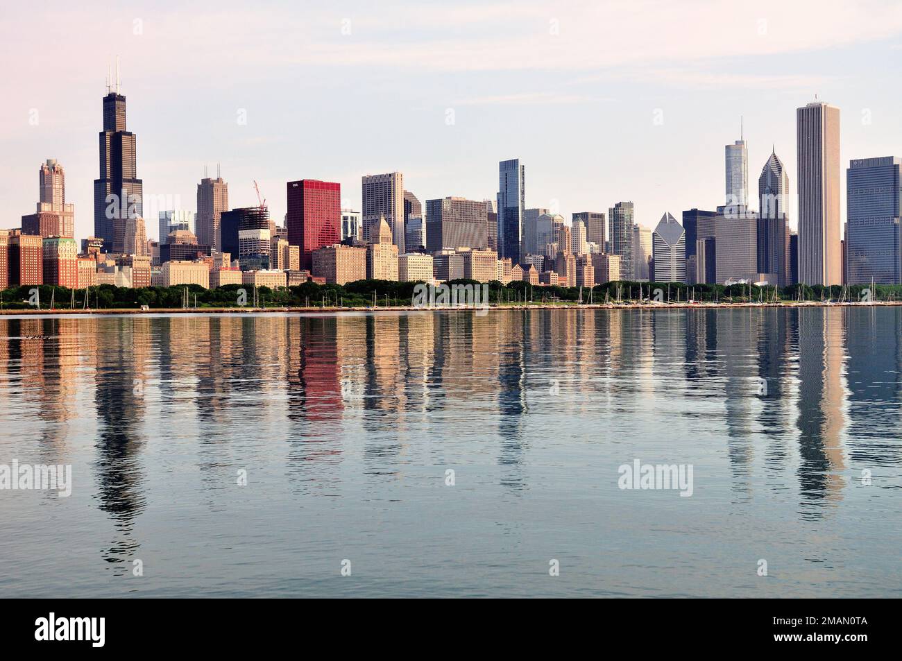Chicago, Illinois, USA. A hazy late spring morning is reflected in Lake Michigan along with buildings comprising the Chicago skyline. Stock Photo