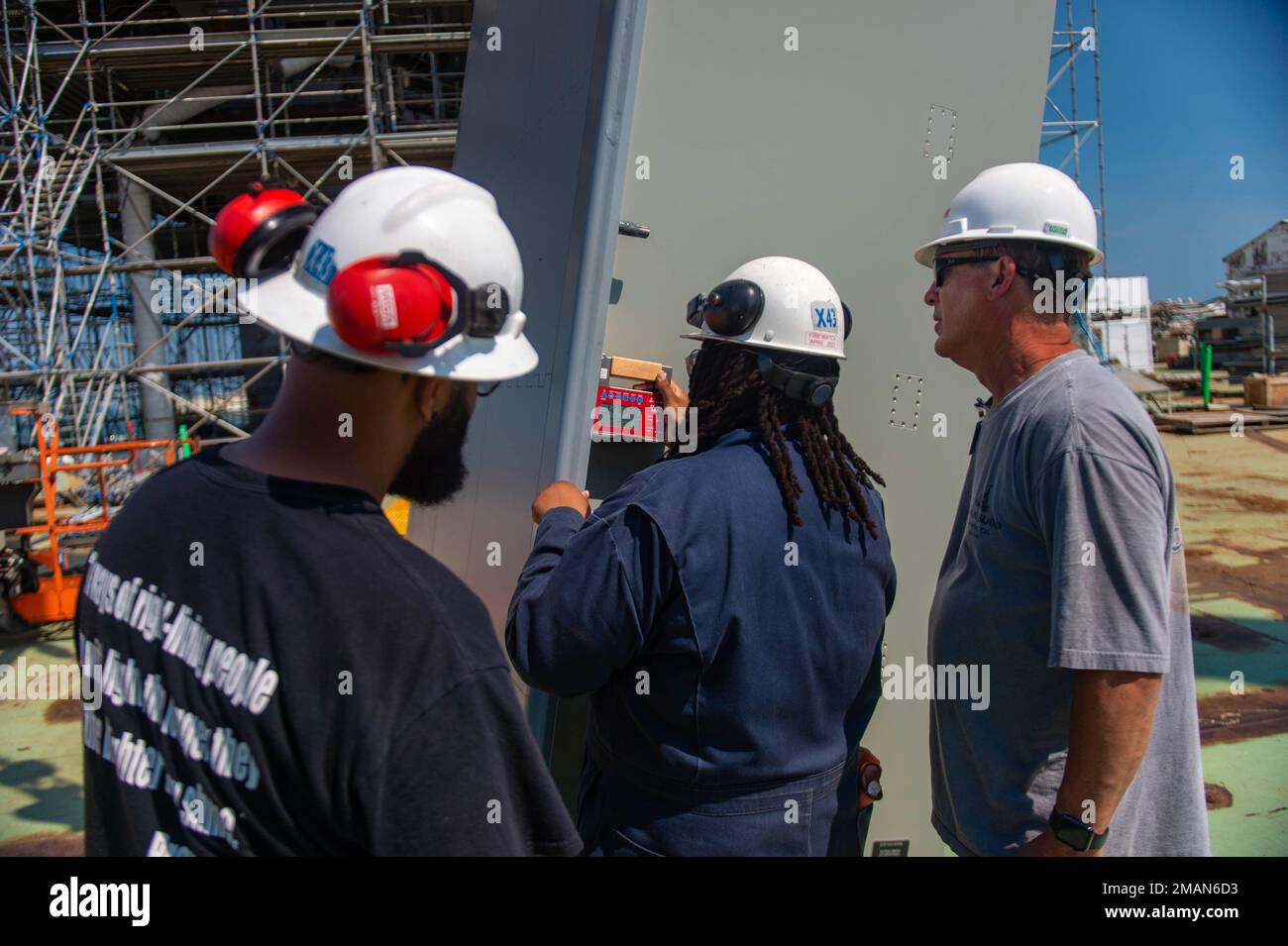 220531-N-NC372-213 From right to left, David Collins from Raytheon Technologies, Jennetta Gilchrist and Darin Lilly with HII’s Newport News Shipbuilding (NNS) division check for the correct angle of one of Pre-Commissioning Unit John F. Kennedy’s (CVN 79) SPY-6(V)3 radars before being installed permanently on John F. Kennedy. The SPY-6(V)3 variant was designed and built by Raytheon Technologies specifically for the U.S. Navy’s Ford-Class of aircraft carriers. The SPY-6(V)3 aboard John F. Kennedy features three fixed-faced array faces, each containing nine radar modular assemblies providing Joh Stock Photo