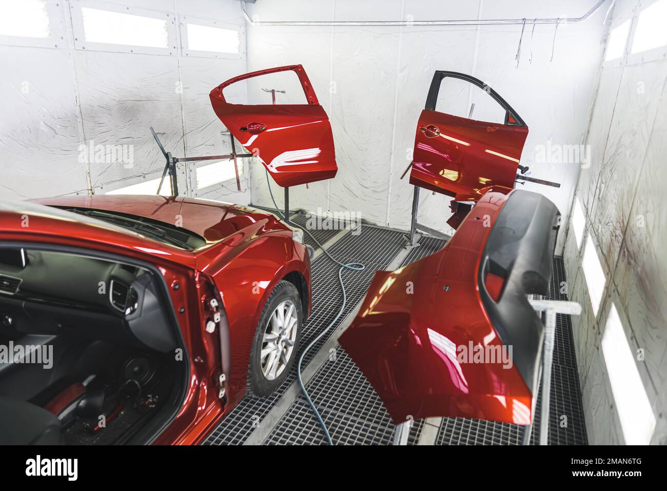 A luxury red car in a paint shop with its doors removed for a fresh coat of paint. High-quality photo Stock Photo