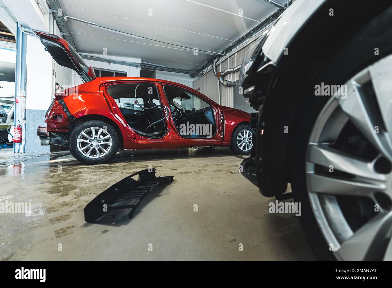An auto body repair shop with luxury cars in various stages of