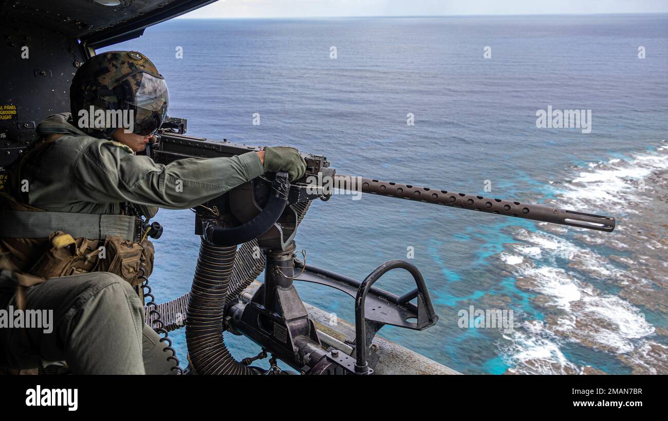 U.S. Marine Corps Sgt. Victor Figueroa, a UH-1Y helicopter crew chief with Marine Medium Tiltrotor Squadron (VMM) 262 (Rein.), 31st Marine Expeditionary Unit (MEU), fires an M2 machine gun during a live-fire exercise off the coast of Okinawa, Japan, Oct. 26, 2022. Katana Strike is led by III Marine Expeditionary Force's Information Group, designed to demonstrate proficiency in coalition joint-force planning, coordination, and execution of dynamic targeting in a maritime environment; the exercise showcases 5th Air Naval Gunfire Liaison Company’s role as the central hub for conducting long-range Stock Photo