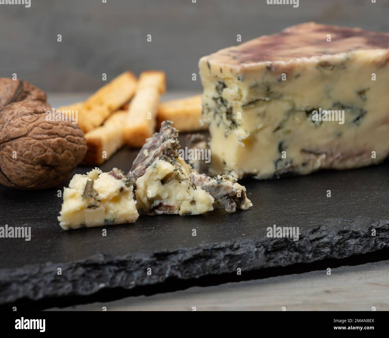 Cheese collection, blue stilton English cheese matured in red porto wine  served as dessert with walnuts and bread sticks close up Stock Photo - Alamy
