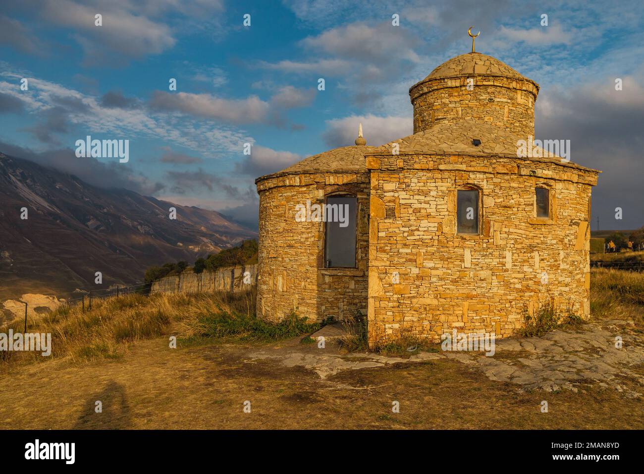 A small stone mosque against the backdrop of picturesque green mountains. Republic of Dagestan, Russia Stock Photo