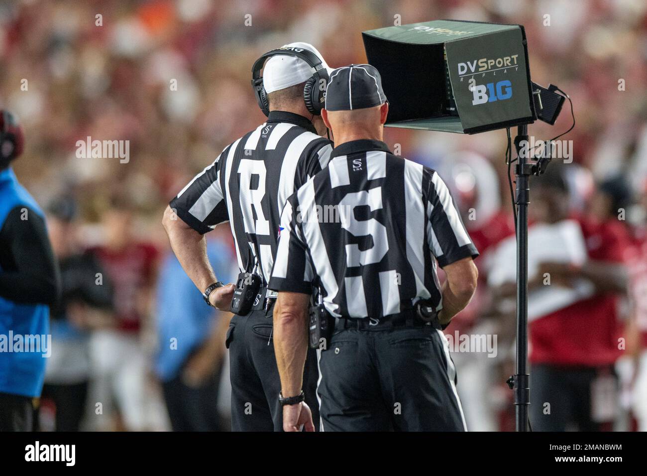 Game officials watch a replay on a monitor during a review of a call during  an NCAA football game on Friday, Sept. 2, 2022, in West Bloomington, Ind.  (AP Photo/Doug McSchooler Stock