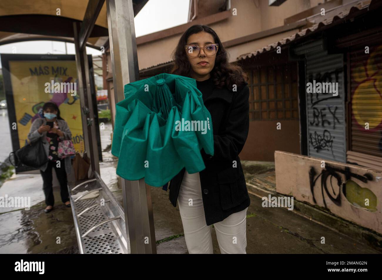 Nicaraguan asylum-seeker Katherine Ramirez waits at the bus stop on her way  home from work in San Jose, Costa Rica, Tuesday, Aug. 23, 2022. The  23-year-old who left Nicaragua in March and