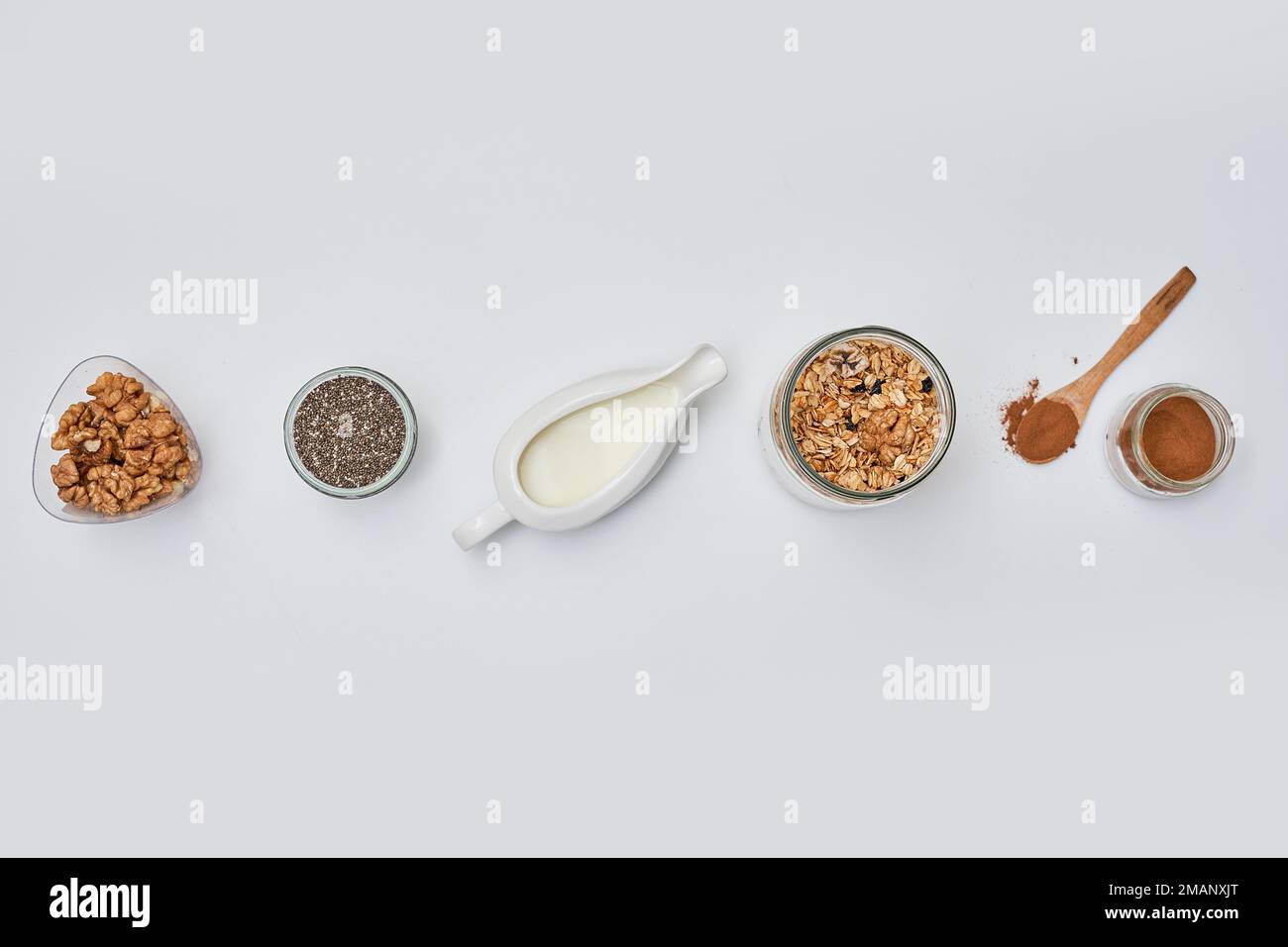 different types of cereals in bowls and spoons on a white background