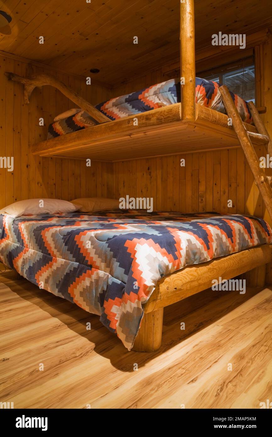 Rustic bunk beds made of logs in guest bedroom in basement inside