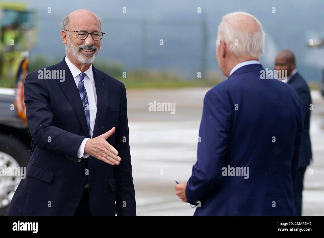 President Joe Biden greets Pennsylvania Gov. Tom Wolf, as he arrives at ...