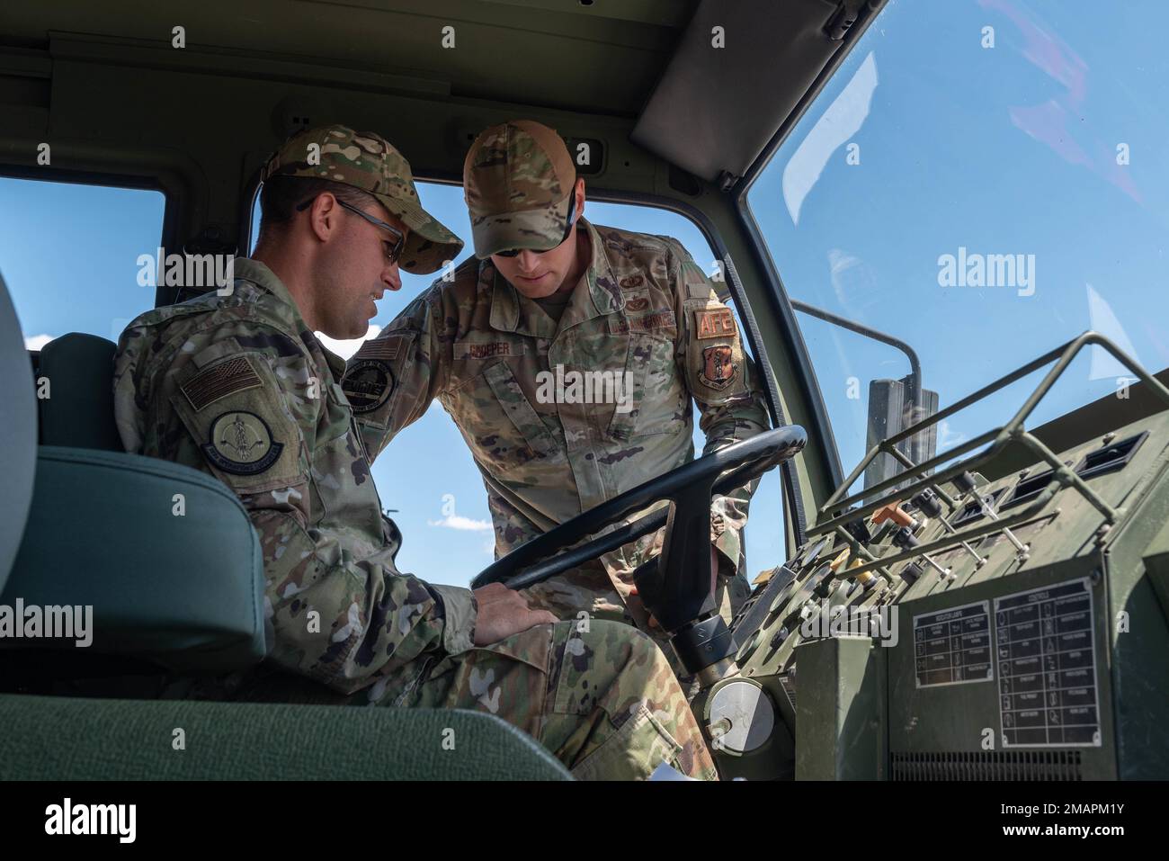 U.S. Air Force Master Sgt. Mike Mitrou and Staff Sgt. Nicholas Groeper, both Aircrew Flight Equipment specialist with the 182nd Operations Support Squadron, Illinois Air National Guard, discuss vehicle operations inside the M1078 cargo truck during a scheduled stop on the convoy to Volk Field Combat Readiness Training Center, Camp Douglas, Wisconsin, June 2, 2022. The 182nd OSS and 169th Airlift Squadron participated in a multi-capable Airman training exercise at Volk Field CRTC from June 2 to June 4, 2022. Stock Photo