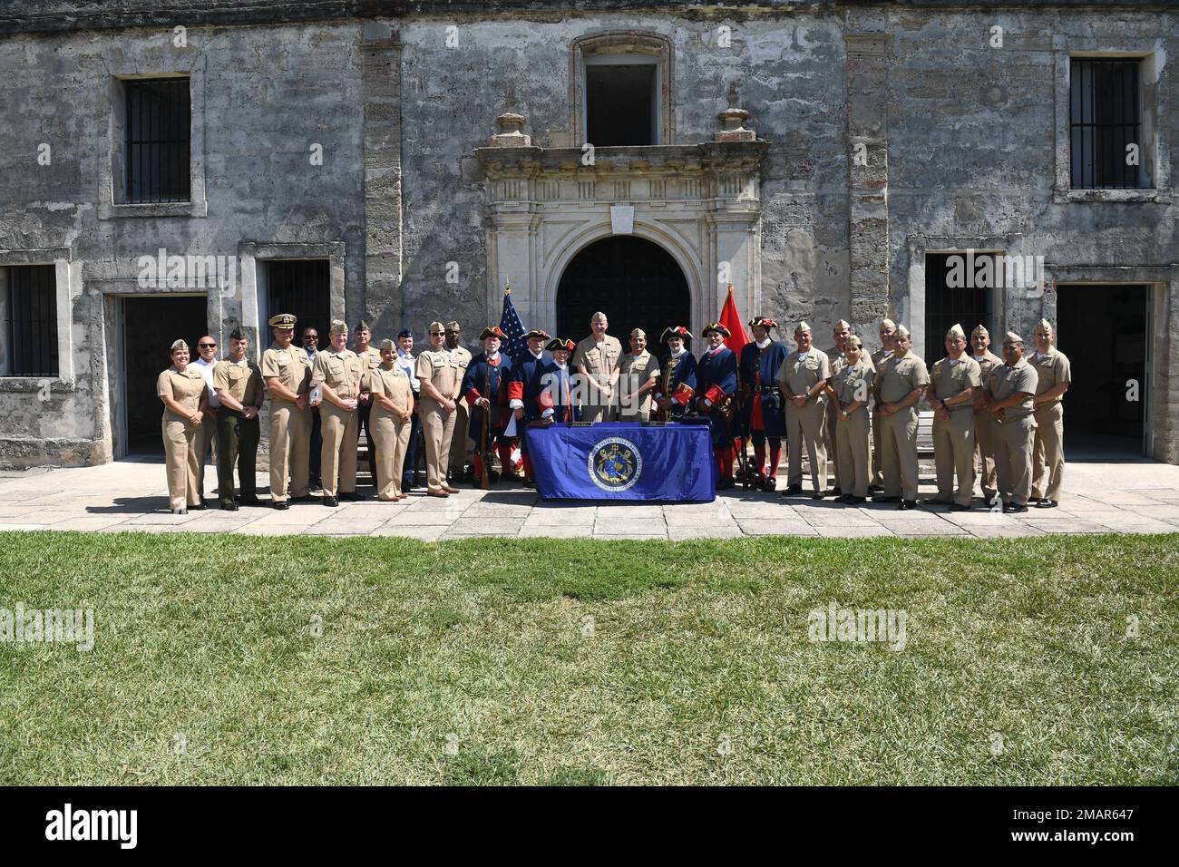 220603-N-DB801-0229  ST. AUGUSTINE, Fla. - (June 3, 2022) – U.S. Navy personnel pose for a group photo alongside sailors from the Peruvian navy, U.S. Coast Guard, U.S. Marine Corps, actors from the 18th century Spanish colonial era, and other distinguished guests at the Castillo de San Marcos National Monument during the closing ceremony of the 28th annual Maritime Staff Talks (MST), June 3, 2022. MSTs support the U.S. maritime strategy by building and strengthening working relationships with U.S. and partner nations. Stock Photo