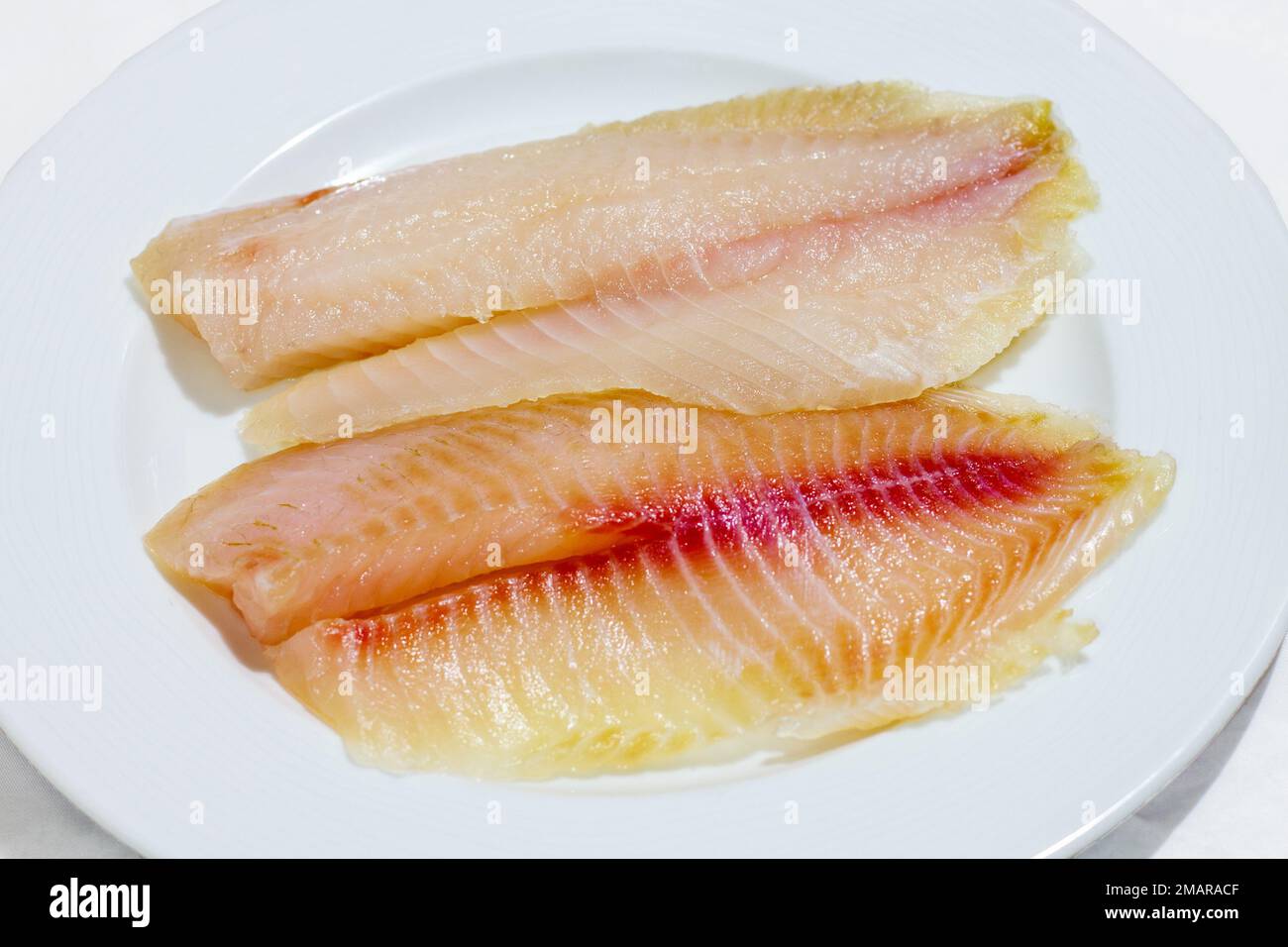 cried fish fillet on a plate on a white background Stock Photo