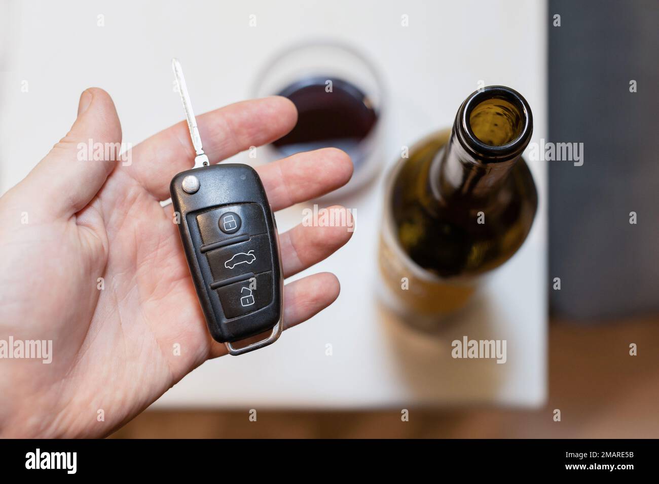 Key of car and a bottle of wine in a background blured background