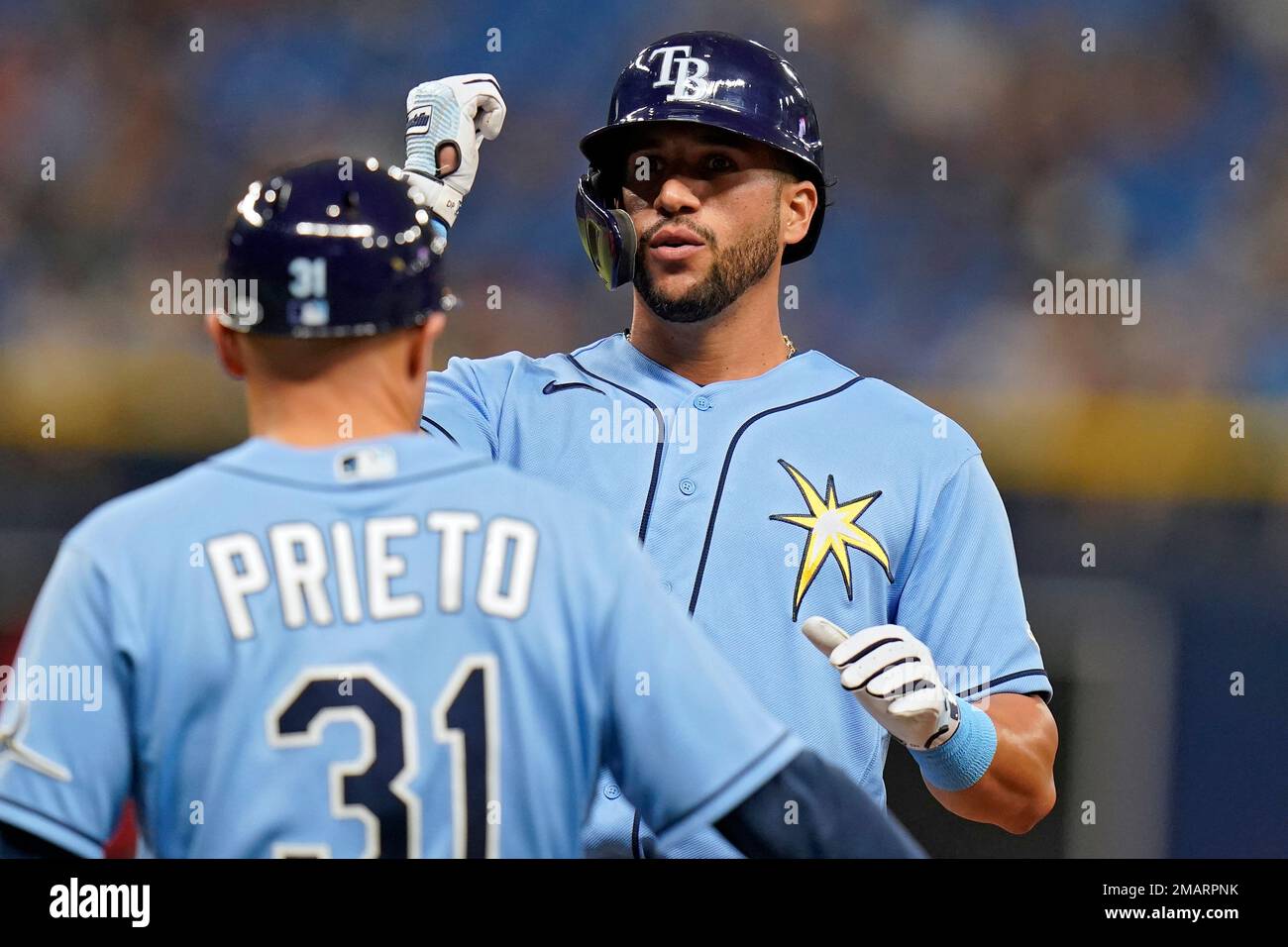 Tampa Bay Rays' David Peralta celebrates with first base coach Chris Prieto  (31) after his single off Los Angeles Angels starting pitcher Tucker  Davidson during the fourth inning of a baseball game