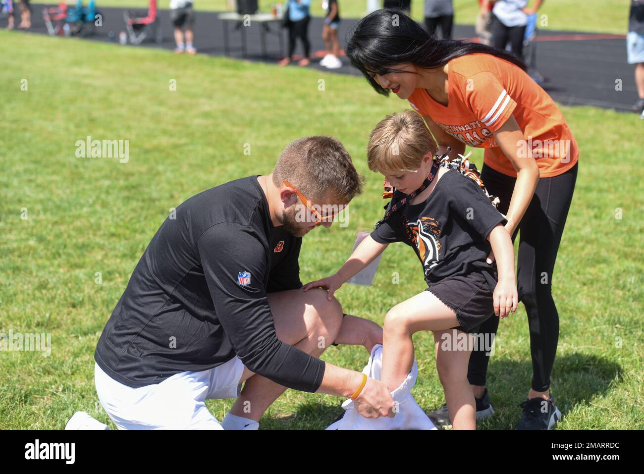 Cincinnati Bengals tight end Justin Riggs helps a Wright-Patterson Air  Force Base, Ohio, military child put on football pants at the USO-sponsored  Cincinnati Bengals football skills clinic, June 3, 2022. A group