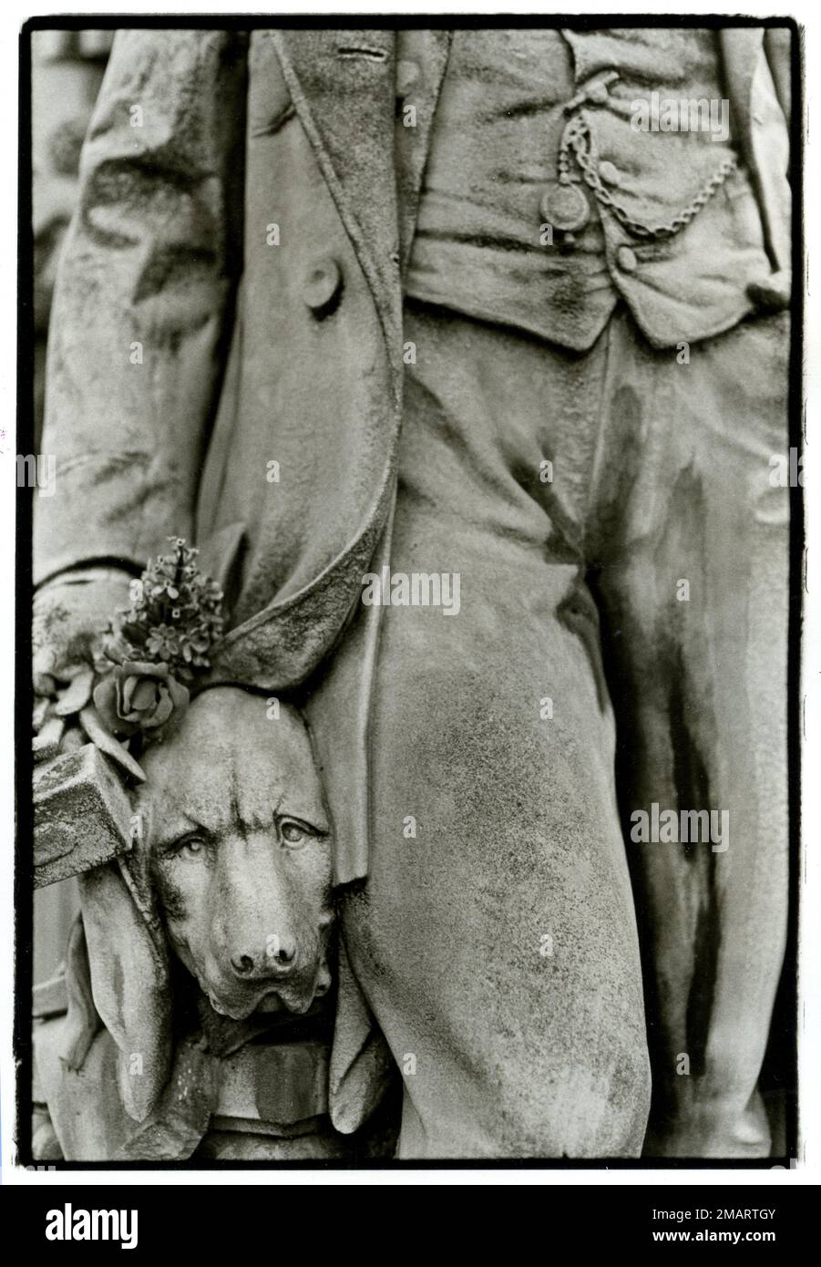Statue depicting a dog with his owner at grave site in the Pere Lachaise cemetery in Paris, France Stock Photo