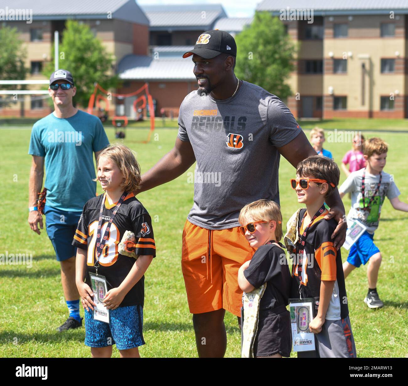 Cincinnati Bengals defensive tackle Zachary Carter poses for a picture with Wright-Patterson Air Force Base, Ohio, military children at the USO-sponsored football skills clinic, June 3, 2022. A group of Bengal rookies had lunch with Airmen, toured the base, and led the skills clinic for 99 Wright-Patt military children. Stock Photo