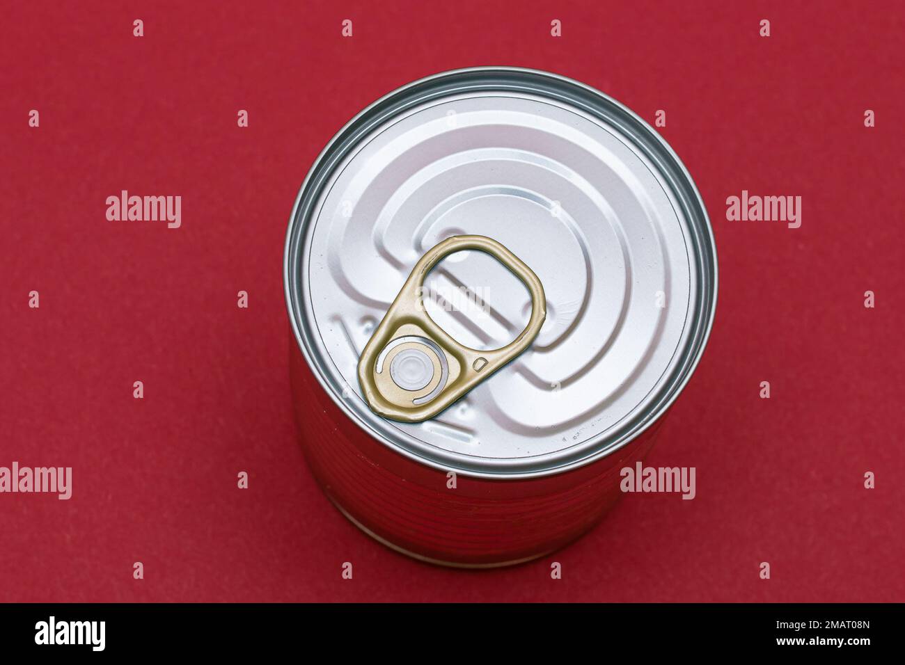 Unopened Tin Can with Blank Edge on Red Background. Canned Food