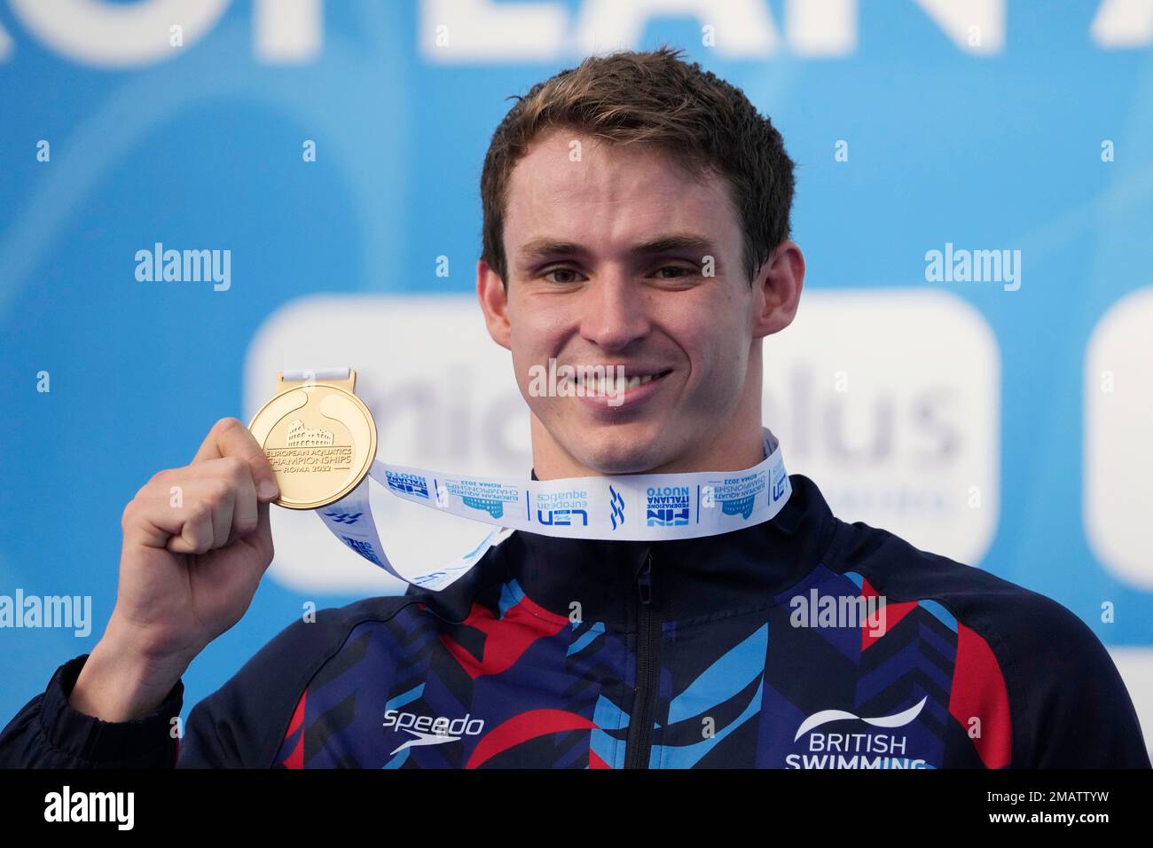 Benjamin Proud of Britain celebrates holding his gold medal on the