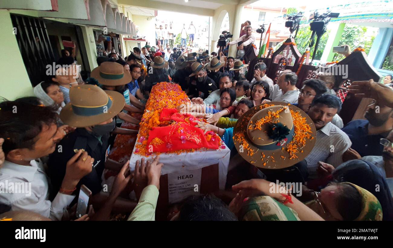 Family members stretch their arms out to touch the coffin containing