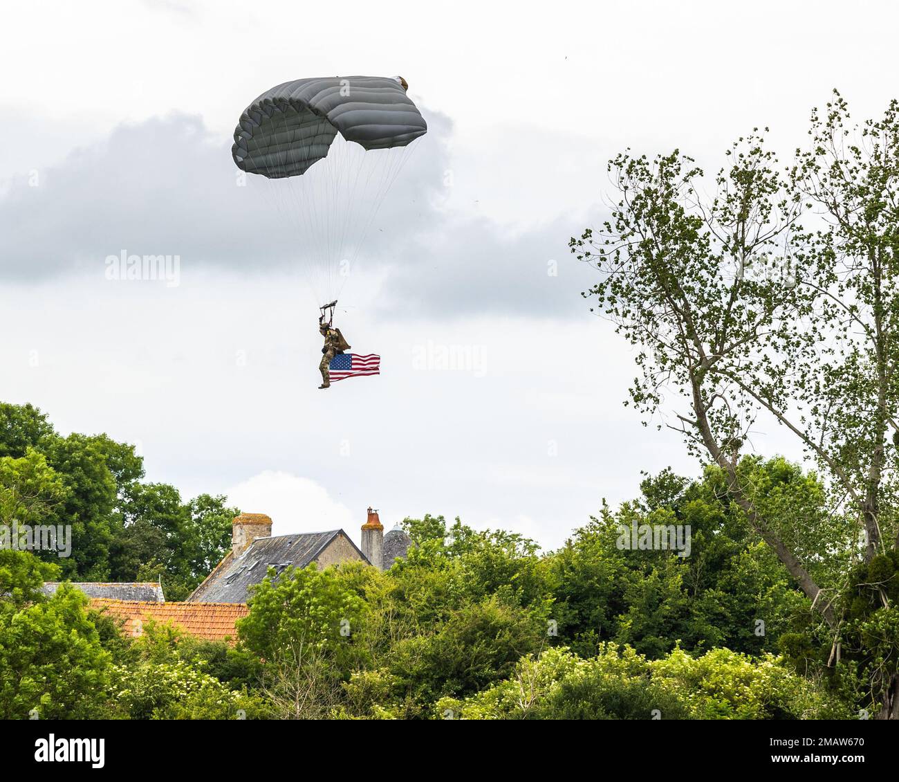 U.S. Army 1-10 Special Forces Group Command Sergeant Major Dennis Kitchin parachutes to a drop zone during a High Altitude Low Opening (HALO) jump for the 78th D-Day commemoration at Sainte-Mère-Église, France, June 5, 2022. Project Jedburgh was a joint Allied program, with the OSS Special Operations (SO) branch, the British Special Operations Executive (SOE), and the French Bureau Central de Renseignements et d’Action (BCRA) and is widely considered the origins from which all modern special operations draw their lineage from. Stock Photo