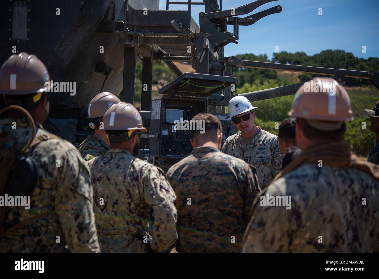 220605-N-MQ841-1357 VANDENBERG SPACE FORCE BASE, Calif. (June 5, 2022) Equipment Operator 2nd Class Thomas Mann, assigned to Naval Construction Group (NCG) 1, instructs U.S Navy Seabees with Naval Mobile Construction Battalion (NMCB) 5 and Marines with Marine Wing Support Squadron 373 how to use the ProAll crete mobile during Operation Turning Point, also known as their Field Training Exercise at Vandenberg Space Force Base. Operation Turning Point is an around-the-clock exercise that focuses on constructing advanced bases while maintaining proficiency in tactics and survivability. NMCB-5 is h Stock Photo