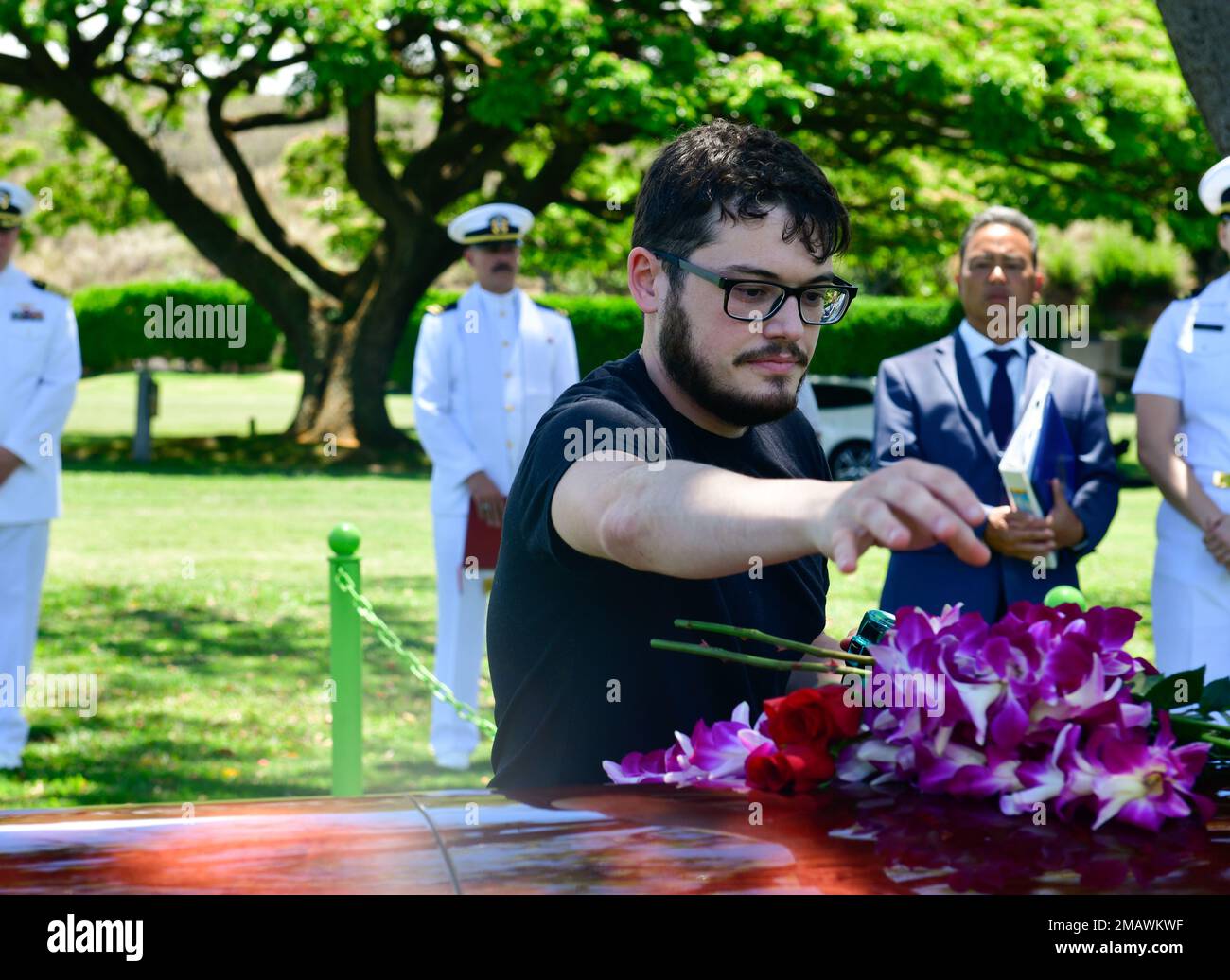 A family member of U.S. Navy Fire Controlman 2nd Class George Gilbert, 20, of Indianapolis, places roses with respect and honor during his internment ceremony at the National Memorial Cemetery of the Pacific, Honolulu, HI, June 6, 2022. Gilbert was assigned to the USS Oklahoma, which sustained fire from Japanese aircraft and multiple torpedo hits causing the ship to capsize and resulted in the deaths of more than 400 crew members on Dec. 7, 1941, at Ford Island, Pearl Harbor. Gilbert was recently identified through DNA analysis by the Defense POW/MIA Accounting Agency forensic laboratory and l Stock Photo