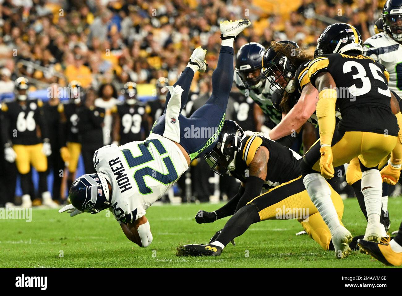 Seattle Seahawks running back Travis Homer (25) toplles over Pittsburgh  Steelers safety Tre Norwood (21) on a run during the first half of an NFL  preseason football game, Saturday, Aug. 13, 2022,