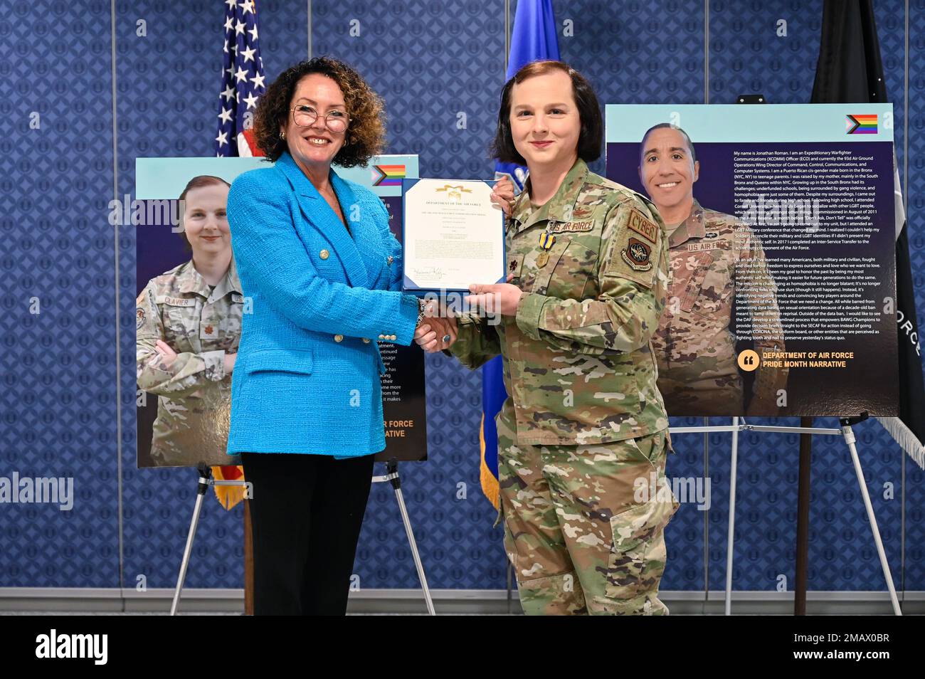 Marianne Malizia, director of diversity and inclusion for the Air Force,  presents the Air and Space Force Commendation Medal to Maj. Julie Clavier  during a Department of the Air Force Pride celebration