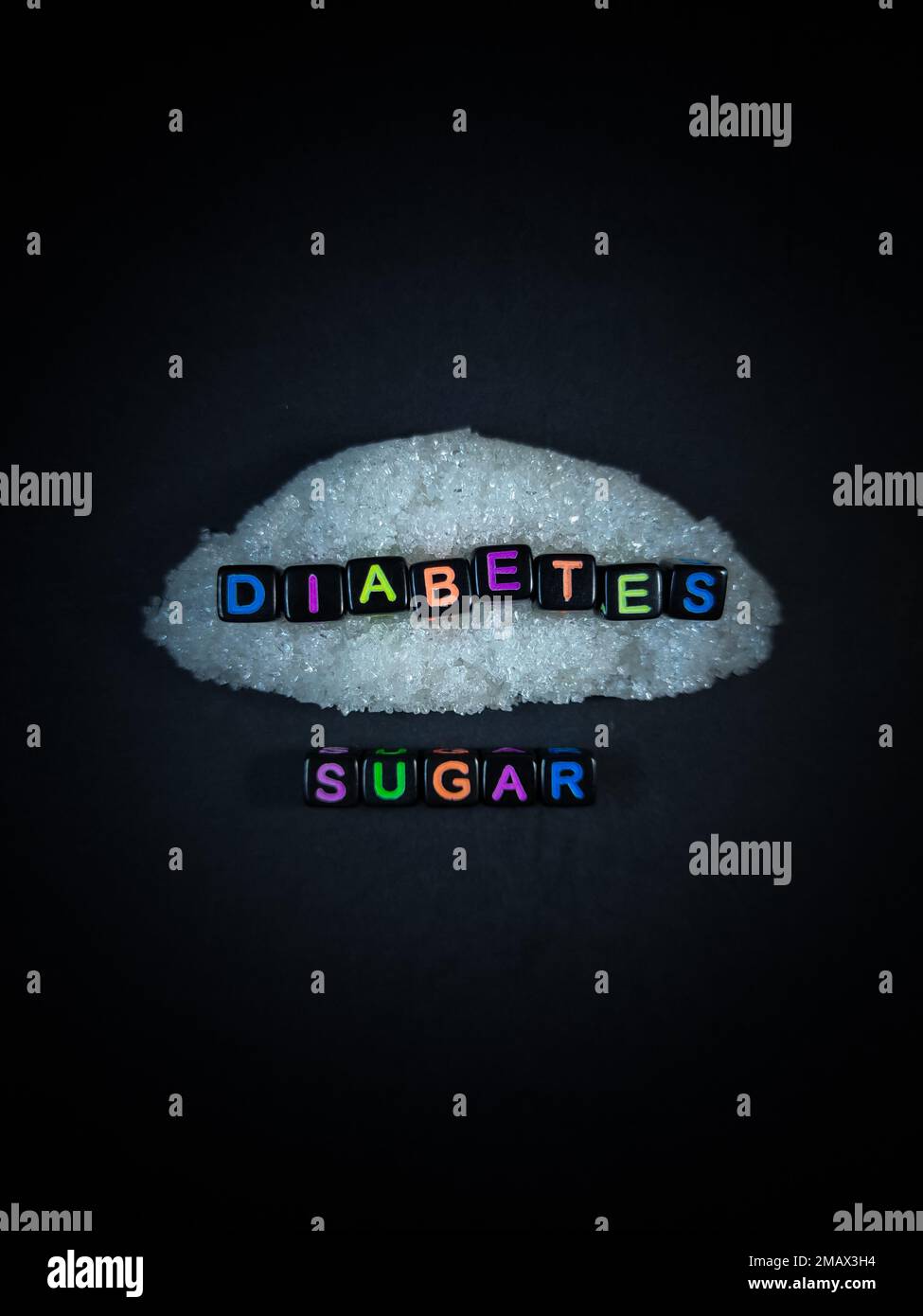 Black bead with color letter in word DIABETES LESS SUGAR with sugar and black background.Top view. Stock Photo
