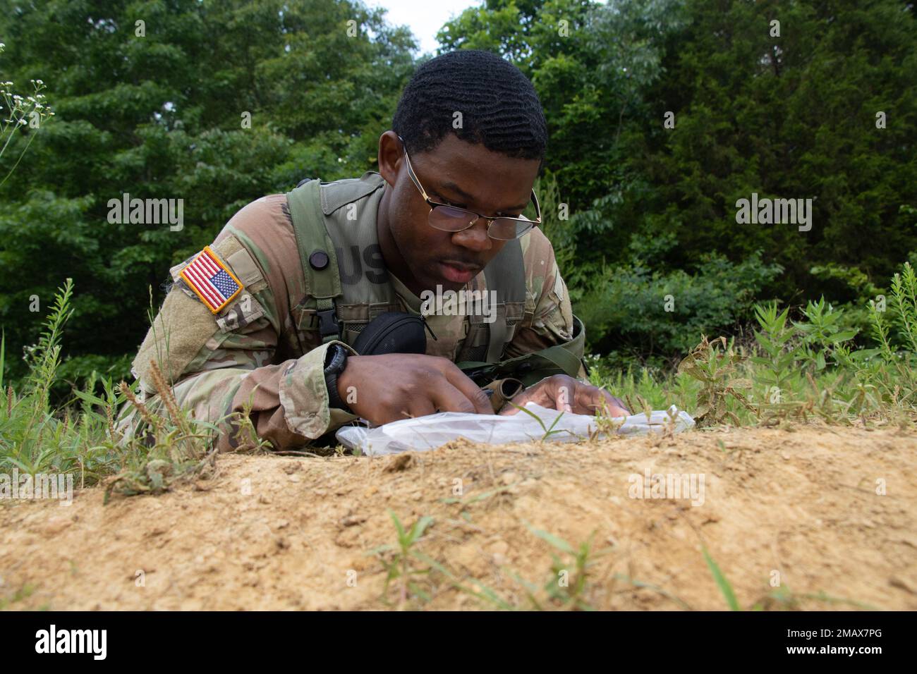 An Army ROTC Cadet studies a map during his land navigation test at Fort Knox, Ky., June 6, 2022. Cadets used maps, compasses and protractors to complete the test, which they have to pass for Cadet Summer Training. | Erinn Finley, CST Public Affairs Office Stock Photo