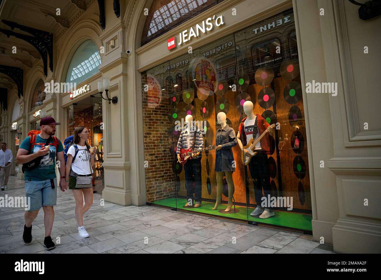 A couple walk past the Jeans'a boutique opened instead of Levi's (Levi  Strauss & Co) American boutique closed due to sanctions in the GUM  department store in Moscow, Russia, Tuesday, Aug. 9,