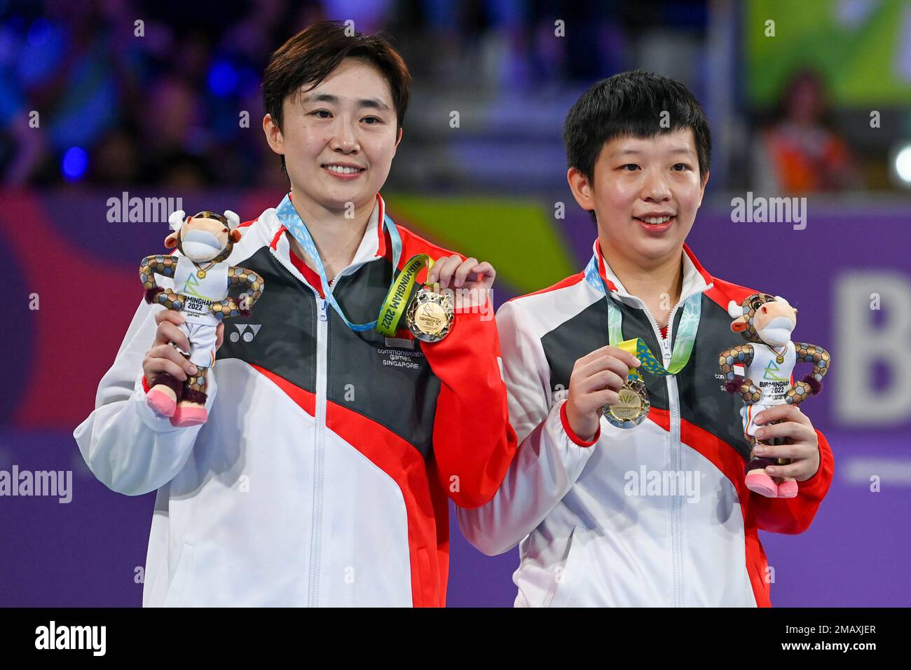 Feng Tianwei and Zeng Jian, right, of Singapore celebrate on the podium