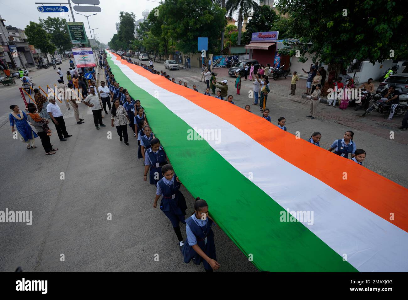 Students walk carrying a 1551 feet (473 meters) long Indian flag as they  mark 75 years of India's Independence, in Ahmedabad, India, Monday, Aug. 8,  2022. India is marking the 75th anniversary