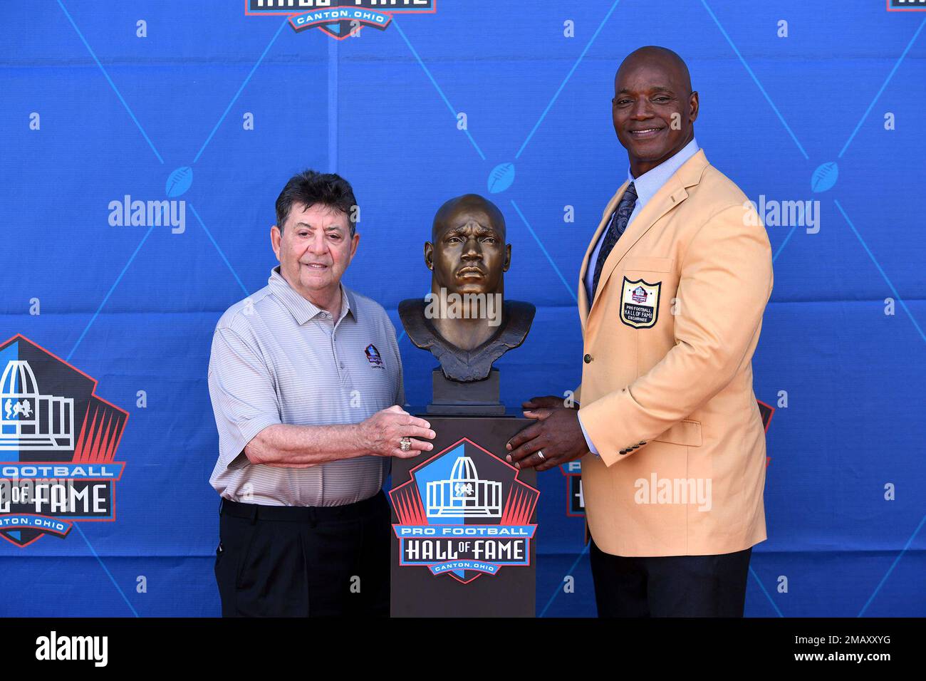 Former NFL player Bryant Young, right, poses with his bust and
