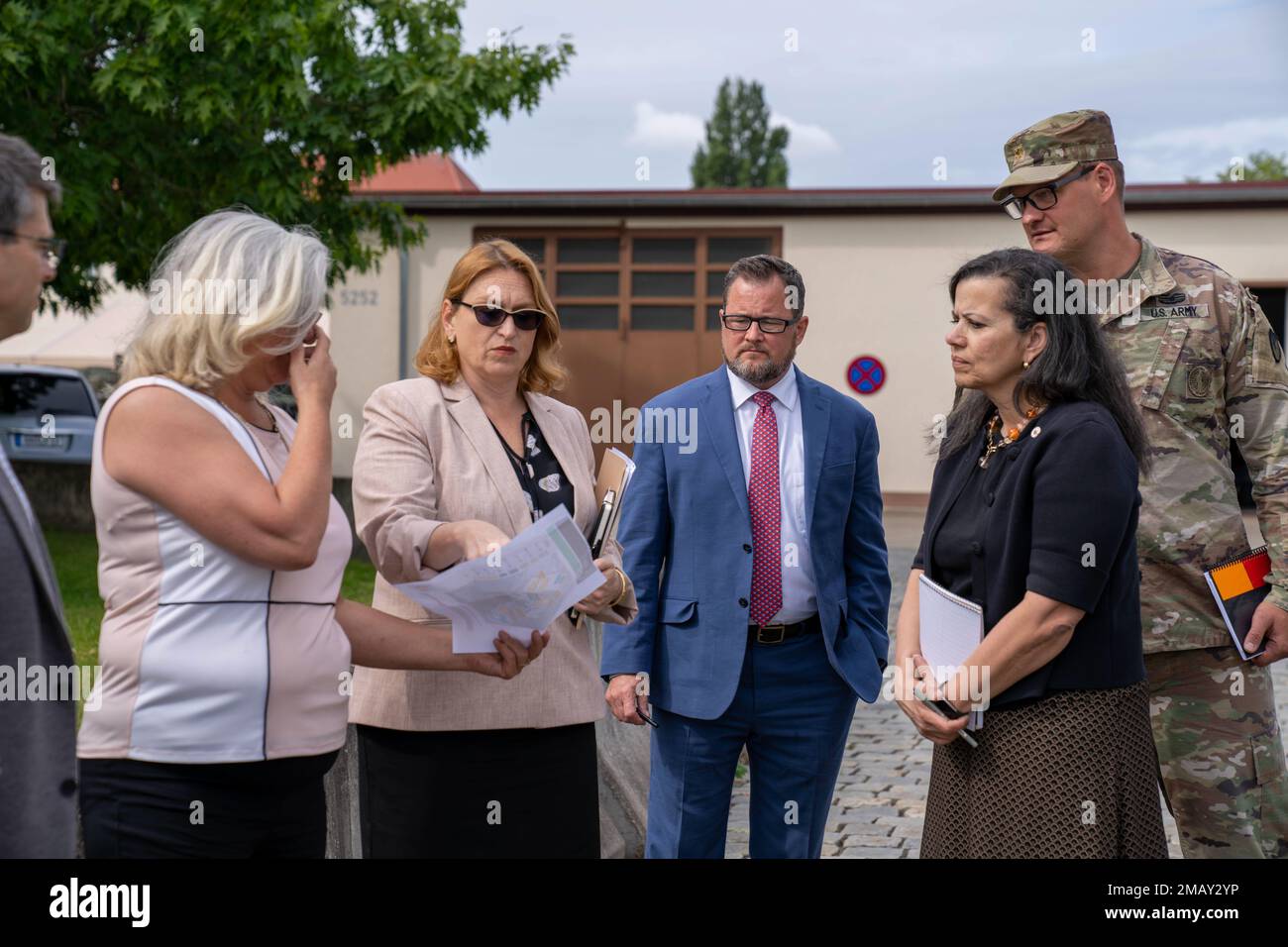 Director of Resources Integration for the Deputy Chief of Staff, G-9,  Headquarters, Department of the Army, Sally Pfenning (center left), points  out plans for future infrastructure to USAG Ansbach employees on Barton  Barracks during an official visit. Stock Photo