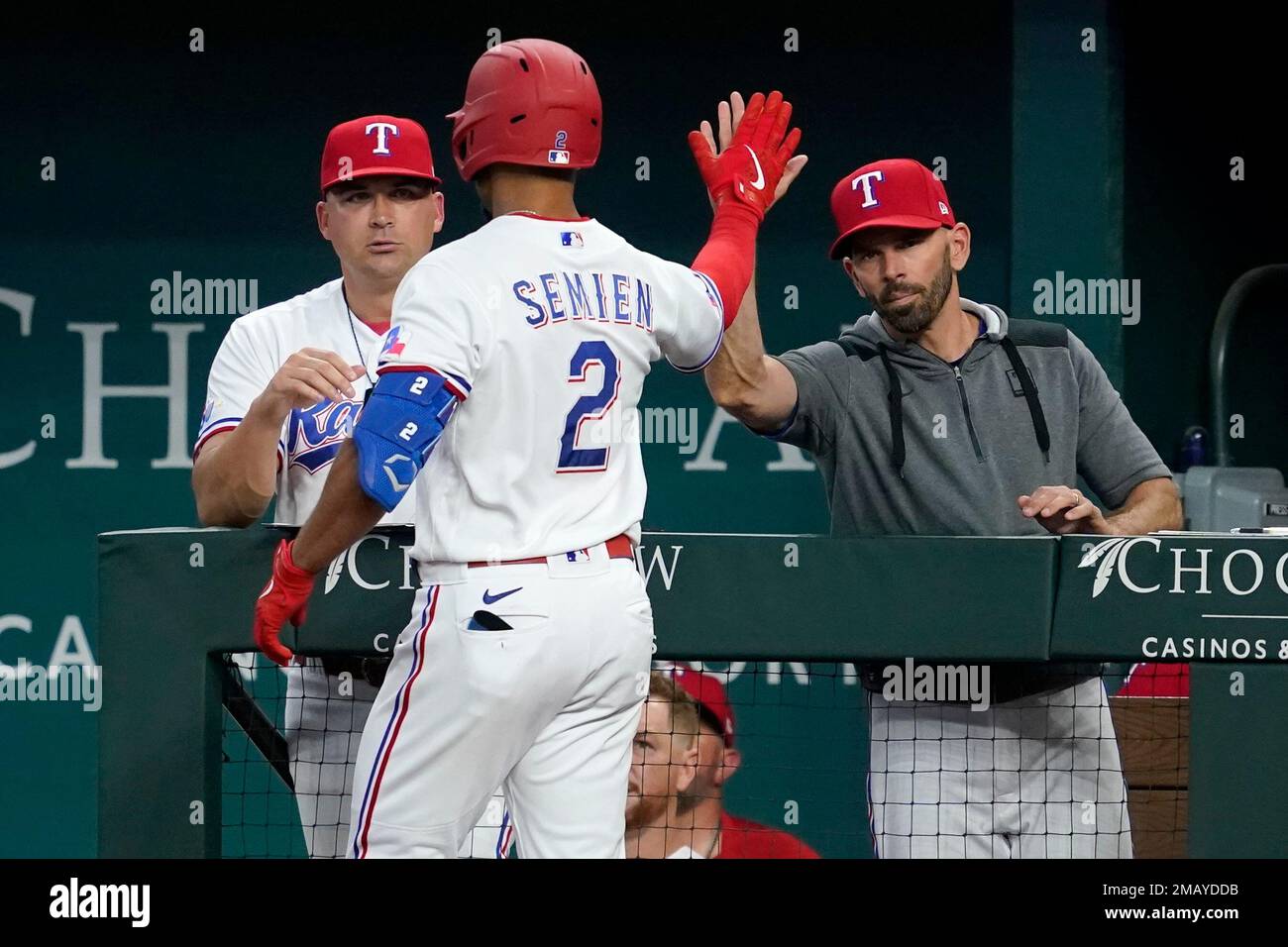 Texas Rangers' Kole Calhoun, left, and bench coach/offensive coordinator  Donnie Ecker, right, celebrate with Nathaniel Lowe (30) after Lowe hit a  solo home run against the Tampa Bay Rays during the fourth